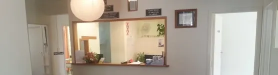 The reception window at the end of the hallway, with flowers on the counter